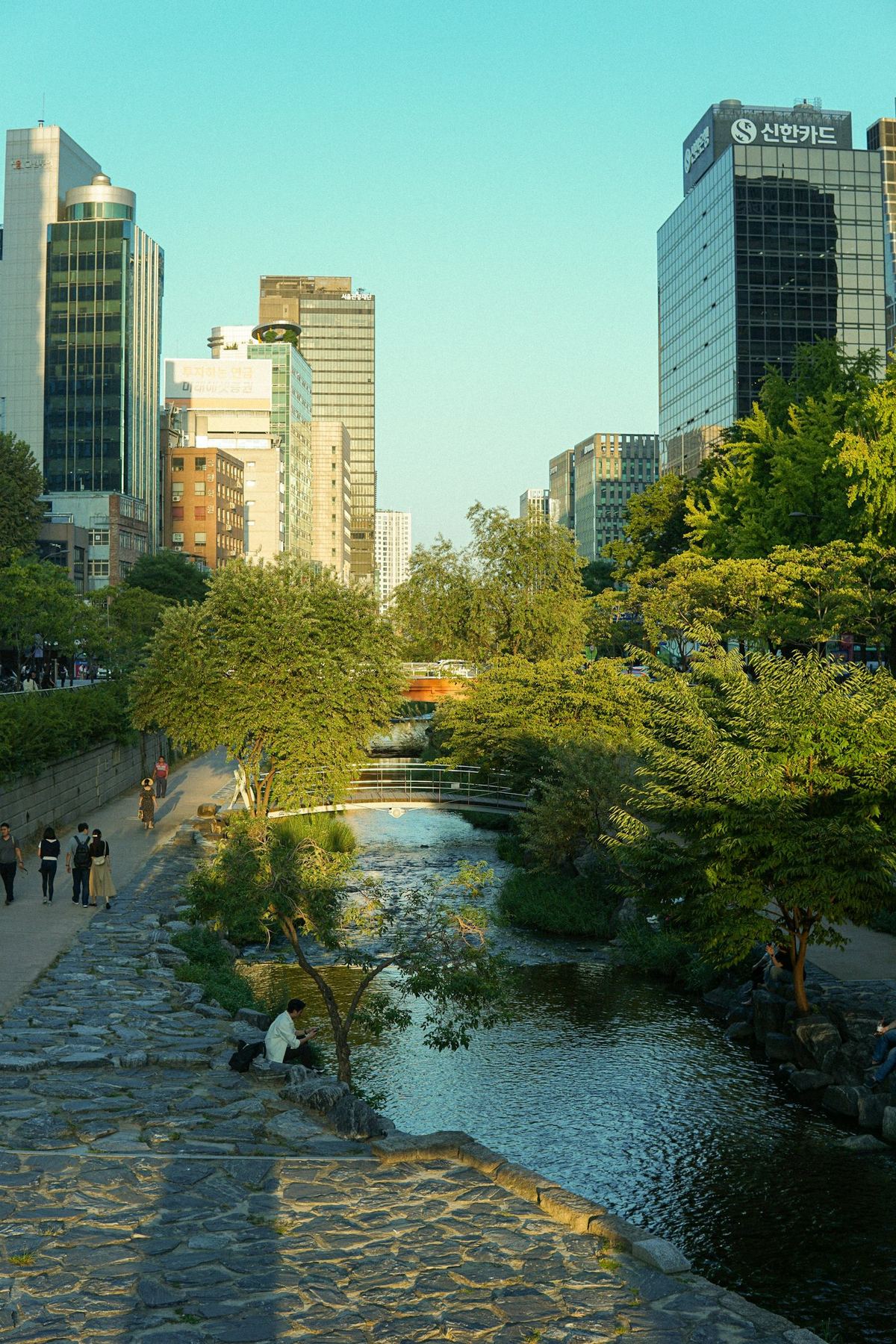 Cheonggyecheon stream running through downtown Seoul with walkers along the stone path
