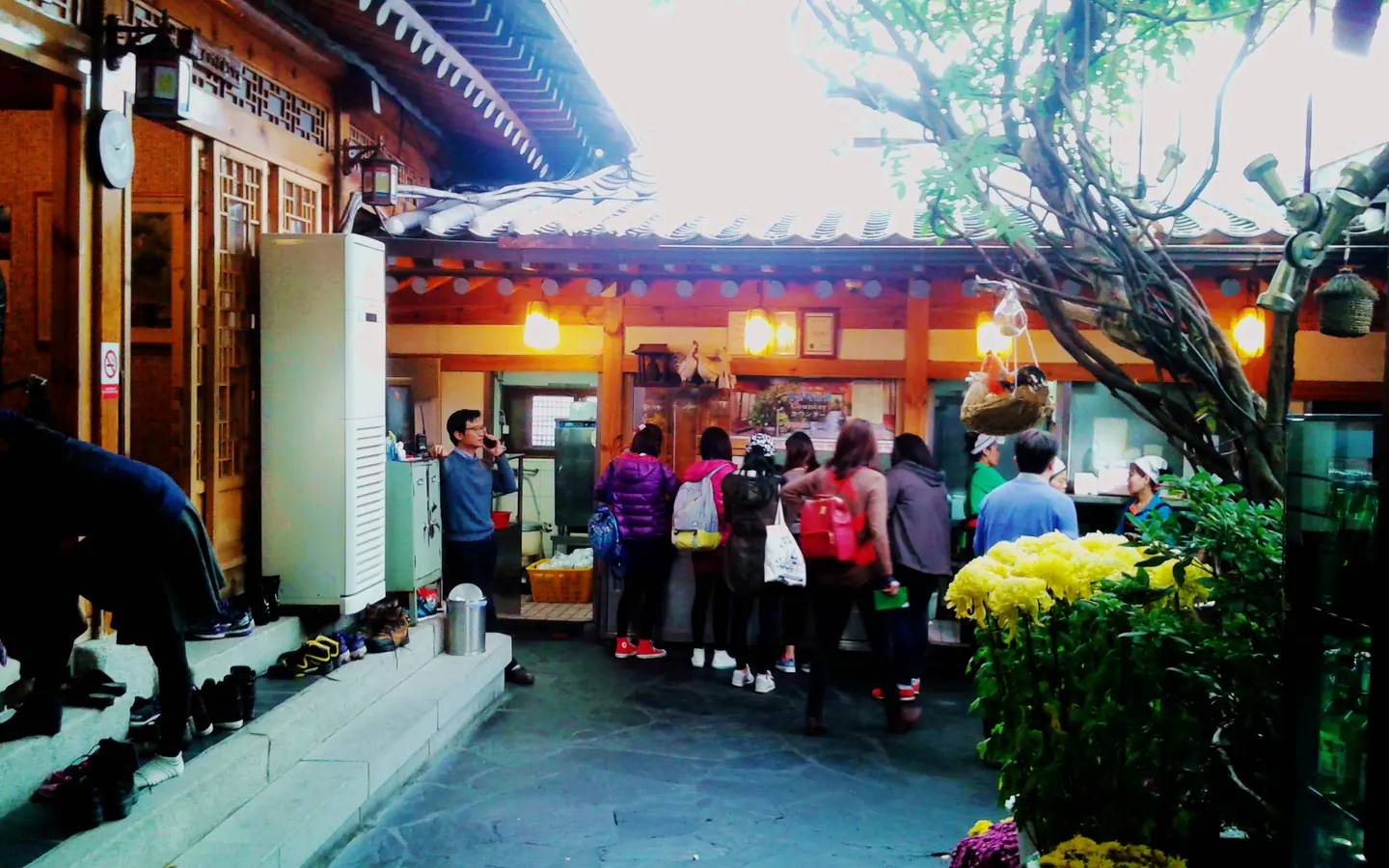 Guests entering a traditional Korean restaurant courtyard in Seoul.